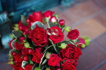 Close up of red wedding bouquet with golden ring