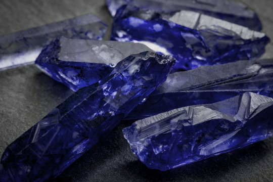 Sapphires and raw crystal gems concept with closeup of a bunch of blue uncut sapphire crystals