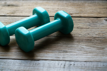 two green dumbbell on a table background, sport and healthy concept