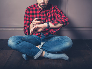 Young man on wooden floor with smart watch