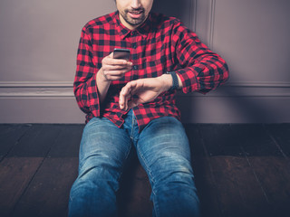 Young man on wooden floor with smart watch