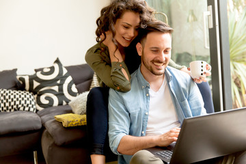 Young couple sitting on floor and using notebook