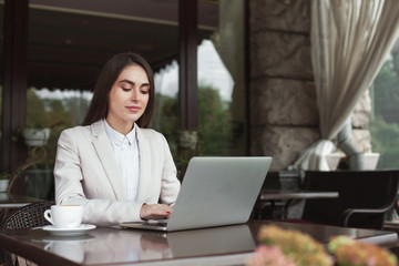 Young businesswoman outdoors working with laptop