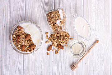 Glass bowl with Greek yogurt and mixed nuts. Healthy vegetarian protein rich diet, homemade granola breakfast with milk, almond, cashew, hazelnut, rolled oats.