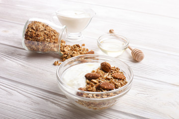 Glass bowl with Greek yogurt and mixed nuts. Healthy vegetarian protein rich diet, homemade granola breakfast with milk, almond, cashew, hazelnut, rolled oats.