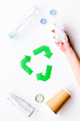 Sorting waste and recycle. Green paper recycling sign on white background top view