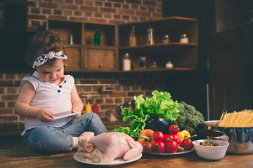 on the table in the kitchen using a smartphone. Child and technology.