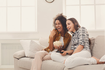Smiling young women watching TV at home