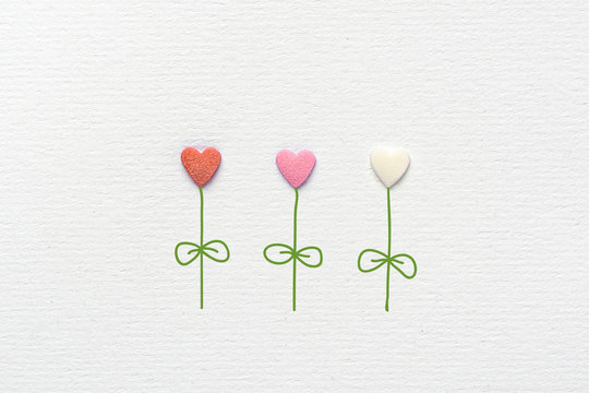Multicolored Flowers in Heart Shape Made of Sugar Candy Sprinkles Hand Drawn Steams Leaves on White Watercolor Paper Background. Creative Mixed Media Image Greeting Card Valentines Easter Mother's Day