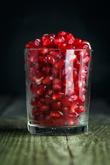 Ripe pomegranate seeds in a tiny glass
