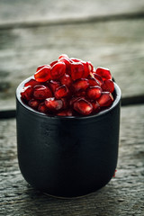 Ripe pomegranate seeds in a small cup