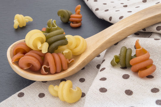 pasta trottole in wooden spoon on cloth background