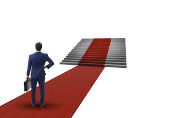 Young businessman climbing stairs and red carpet on white backgr