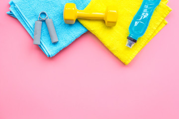 Equipment for sport exercise. Fitness background. Dumbbells, expander on pastel pink background top view copy space