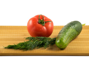 Cucumber, tomato and dill on wooden board
