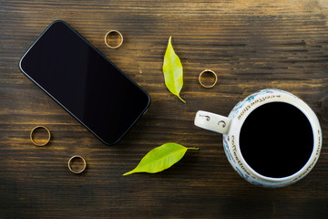 Naklejka premium Cup of coffee, a phone, spectacles, gloves, red autumn leaves