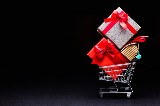 shopping cart with gifts on a black background