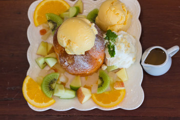 Sweet ice cream with sliced fruit on wood table,Closeup mix fruit and Ice cream
