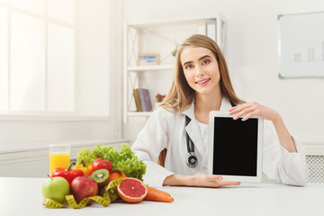 Doctor nutritionist and holding digital tablet