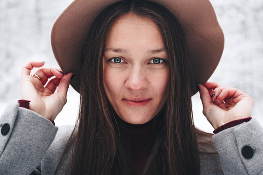 Face of a beautiful and cute woman close-up in vintage hat on background winter view