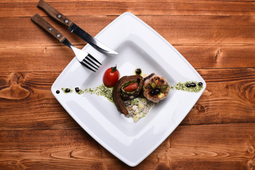 Grilled steak slice, rolled on salad near grilled garlic