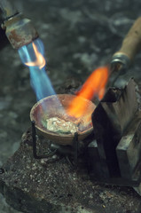Craft jewelery making with professional tools. Macro shot. A handmade jeweler process, manufacture of jewellery. Melting metal