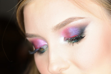 Lady with seductive look and colorful makeup on black background