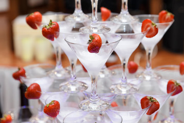 pyramid from glasses of champagne with strawberry on wedding party