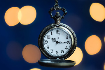 Bronze old pocket watch with blurry light bokeh background