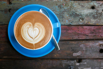 Cappuccino with heart on old wooden table