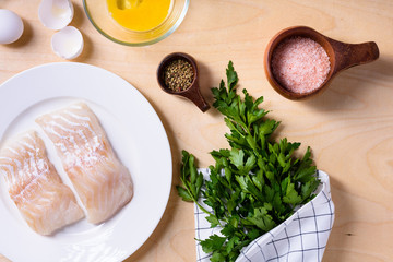 Raw fish cooking and ingredients. Cod fillet, egg and rice.