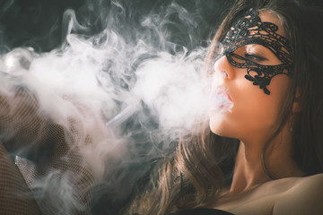 Young, beautiful girl smoke a hookah at club