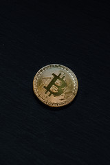 Bitcoin gold coin on black background. Cryptocurrency content.