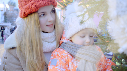 Mother and her little son are enjoying winter holidays at the Christmas fair