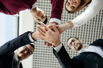 Close-up of business partners making pile of hands at meeting. Team work.