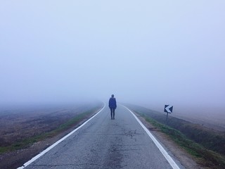 una persona sulla strada nella nebbia