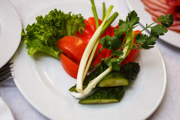 Chopped red and green peppers on a white plate with a chopped red onion isolated on a white