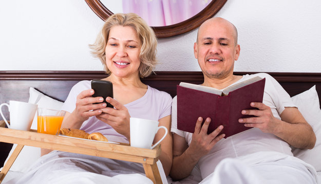 Mature couple having breakfast in bed.