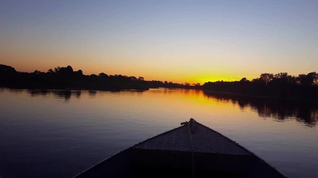Boat sails towards the sunset. Image in the Pantanal Biome. Mato Grosso do Sul state, Central-Western - Brazil.