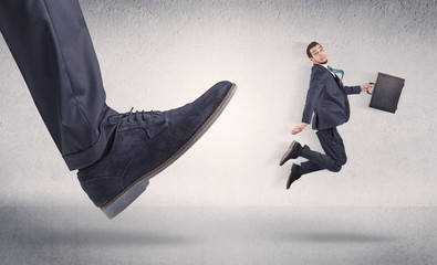 Small businessman kicked by big shoe