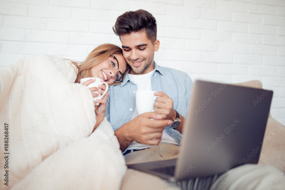 Sticker Couple with a laptop sitting under the blanket.