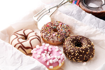 assorted donuts with chocolate frosted, pink glazed and sprinkles donuts.