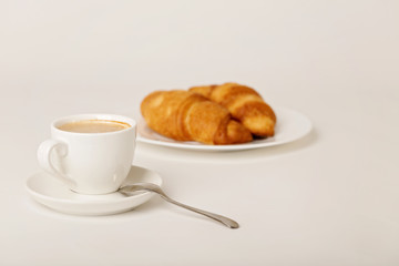 Breakfast - coffee with croissants on a white background.