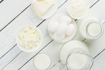 Different dairy products, white wooden background