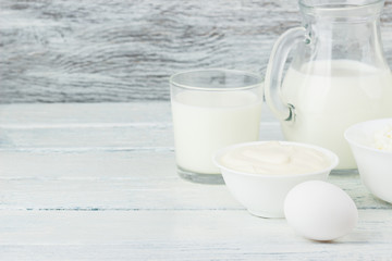 Different dairy products, white wooden background