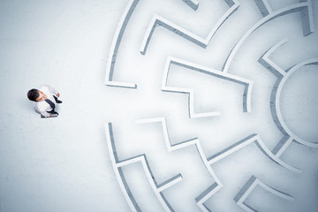 Business man looking at circular maze with nowhere to go