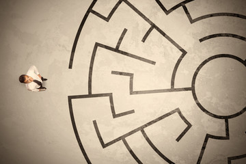 Lost business man looking for a way in circular labyrinth