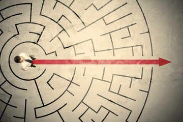 Business person standing in the middle of a circular maze