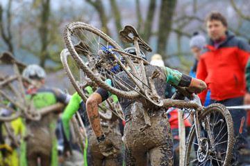 Naklejka premium ciclocross competición ciclista con la bicicleta al hombro en pista de barro país vasco 4M0A4600-f18