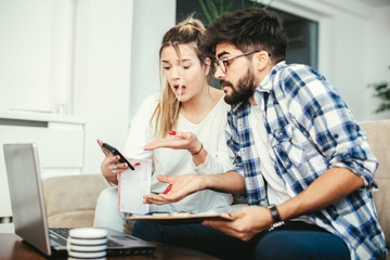 Obraz premium Woman and man doing paperwork together, paying taxes online on notebook pc